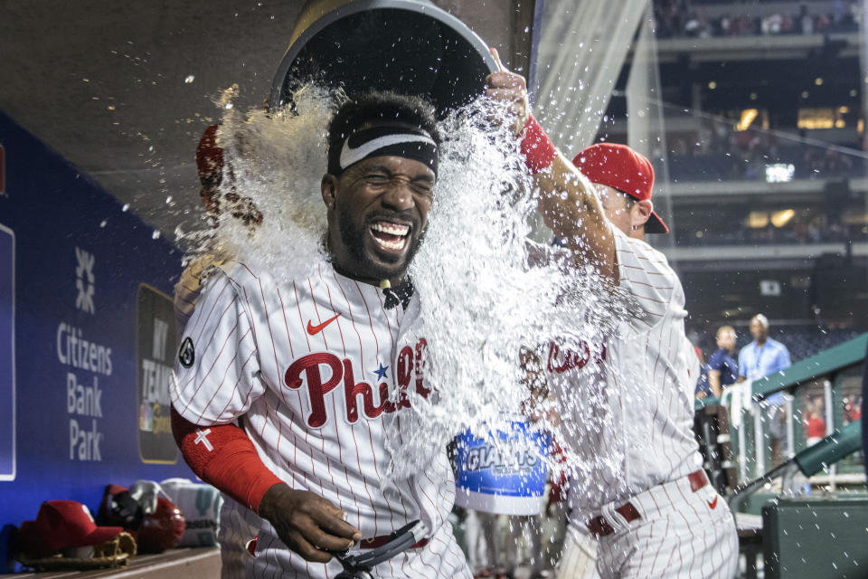 Philadelphia Phillies Andrew McCutchen is doused by teammates Rhys Hoskins and Archie Bradley after hitting a three-run walkoff home run in the ninth inning of a baseball game against the Washington Nationals, Monday, July 26, 2021, in Philadelphia. (AP Photo/Laurence Kesterson)