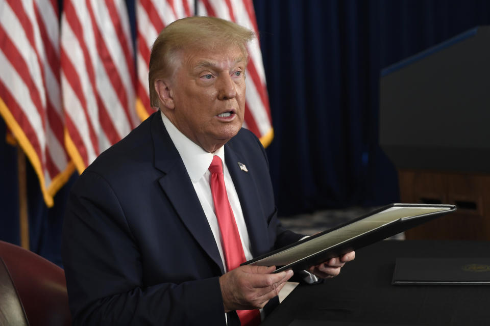 FILE - President Donald Trump prepares to sign four executive orders during a news conference at the Trump National Golf Club in Bedminster, N.J., in a Saturday, Aug. 8, 2020 file photo. New York Gov. Andrew Cuomo has dismissed as laughable the executive order President Donald Trump signed to force states to pay part of $400 weekly unemployment insurance benefits. Cuomo told a telephone news conference Sunday, Aug. 9, 2020 that the plan announced by Trump a day earlier would likely cost New York state $4 billion. Cuomo called it an impossibility. (AP Photo/Susan Walsh, File)