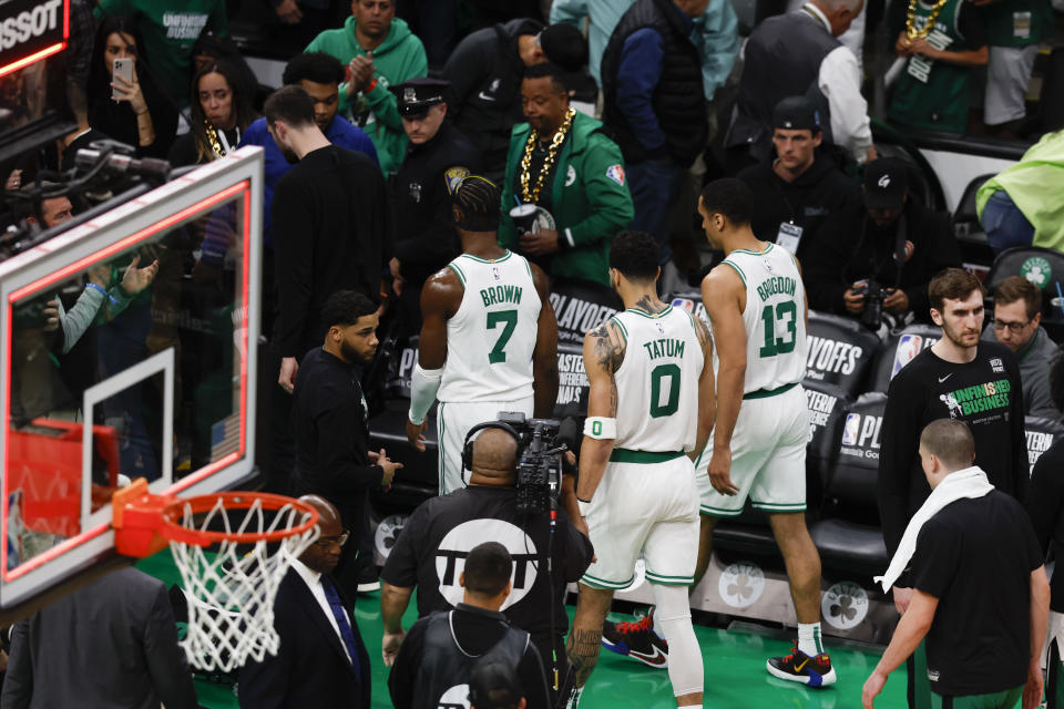 Boston Celtics guard Jaylen Brown (7), forward Jayson Tatum (0) and guard Malcolm Brogdon (13) walk off the court after losing to the Miami Heat in Game 1 of the NBA basketball Eastern Conference finals playoff series in Boston, Wednesday, May 17, 2023. The Heat won 123-116. (AP Photo/Michael Dwyer)