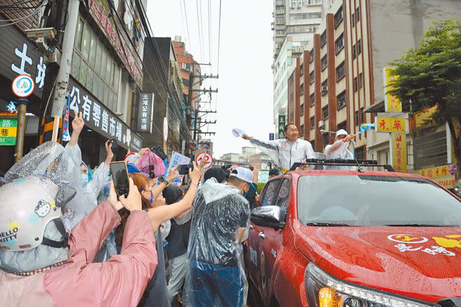 新北市長侯友宜23日前往土城車隊掃街，現場雨勢不斷，但不少支持者仍到路邊，幫他加油打氣，比出「YA」勝利手勢。（蔡雯如攝）