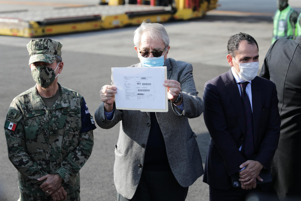 Mexico's Health Secretary Jorge Alcocer holds up the DHL shipping label for the first shipment of the Pfizer COVID-19 vaccine to Mexico at the Benito Juarez International Airport in Mexico City, Wednesday, Dec. 23, 2020. (AP Photo/Eduardo Verdugo)