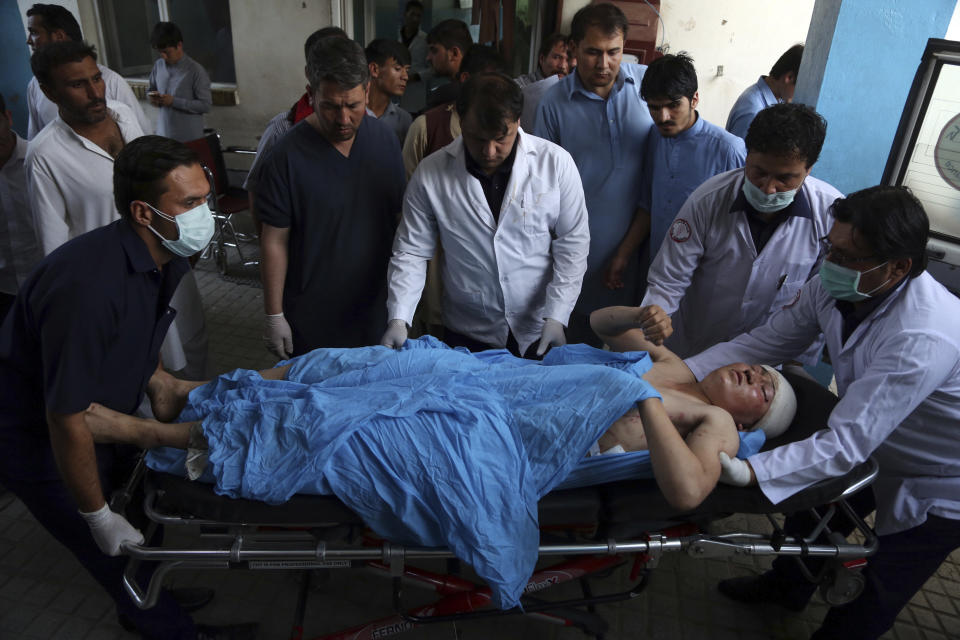 An injured man is put into an ambulance following a deadly suicide bombing that targeted a training class in a private building in the Shiite neighbourhood of Dasht-i Barcha, in western Kabul, Afghanistan, Wednesday, Aug. 15, 2018. The public Health Ministry said the casualty toll has risen to at least 48 dead and dozens wounded. (AP Photo/Rahmat Gul)