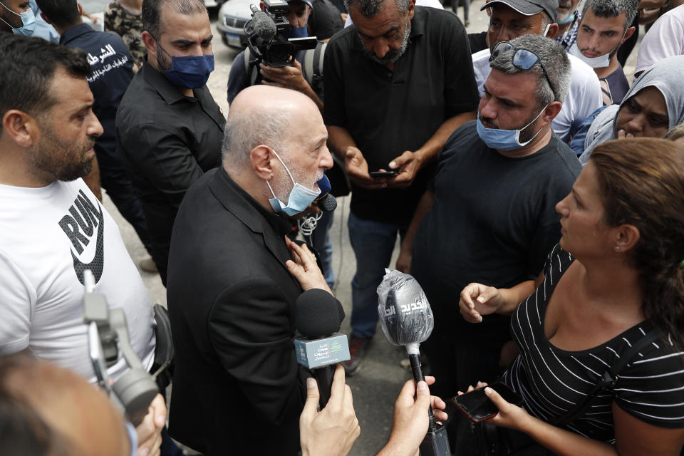 Amin Sherri, a Lebanese lawmaker of the Hezbollah bloc, center, speaks with families of the victims who were missing from the Aug. 4 explosion that hit the seaport of Beirut, Lebanon, Thursday, Aug. 6, 2020. For many, the Iran-backed Hezbollah now stands at the top of Lebanon’s sectarian-based system of power — and so is complicit in the corruption many blame for the port disaster and for driving the country into near bankruptcy. (AP Photo/Hussein Malla)