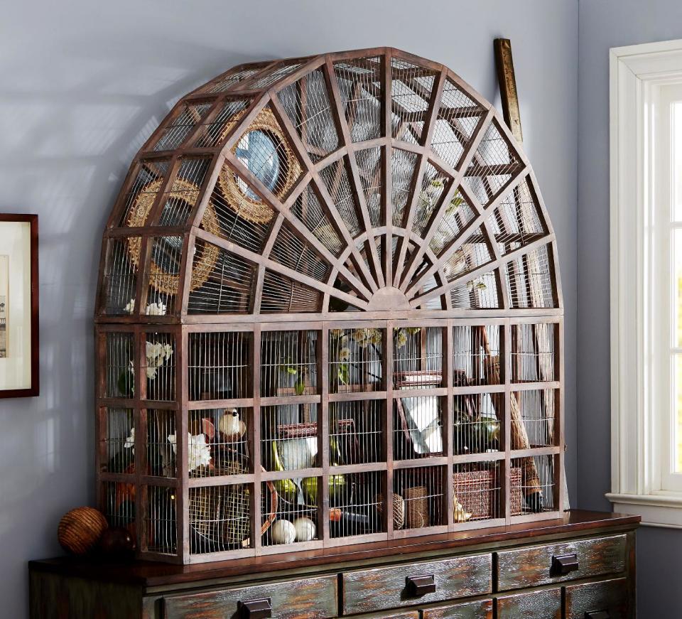 In this photo provided by Pottery Barn, this large Conservatory bird cage made of mahogany and wire is a statement piece due to its scale, and replicates similar designs of the Victorian era. It would look striking alone, or filled with elements of a personal collection, or even plants. Those drawn to 19th-century style may be happy to learn that vintage garden decor is a trend for spring and summer. (AP Photo/Pottery Barn)