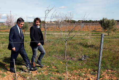 Francois Fillon, former French prime minister, member of the Republicans political party and 2017 presidential election candidate of the French centre-right walks in vineyards with a winegrower in Nimes, France, March 2, 2017. REUTERS/Jean-Paul Pelissier