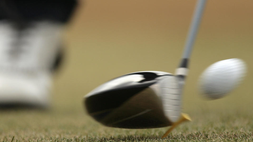     Close-up of a club hitting a ball off the tee 