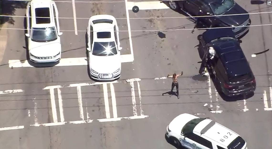 A shirtless man, suspected in a burglary, surrenders to approaching police vehicles at South and East boulevards in Charlotte, NC, on Wednesday, July 6, 2022. The suspect led police and news helicopters on a drive that started near uptown, headed south to Interstate 485, then as far north as Interstate 85 and Statesville Avenue, and as far south as Indian Land, S.C. The drive wound through several neighborhoods and included four stolen vehicles and two wrecks.