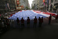 <p>Macy’s marches the world’s largest American flag to hang in a department store during the Chicago Memorial Day Parade on Saturday, May 28, 2016, in Chicago. The 5,000-square-foot flag pays tribute to the fallen and celebrates the 100th anniversary of when first marched in Chicago’s Preparedness Parade on June 3, 1916. (John Konstantaras/AP Images for Macy’s) </p>