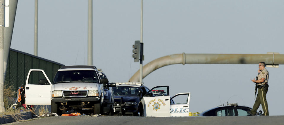 Authorities investigate the scene on the Eastridge Avenue overpass over Interstate 215, where a fatal shootout occurred, Monday, Aug. 12, 2019, in Riverside, Calif. (Terry Pierson/The Orange County Register via AP)