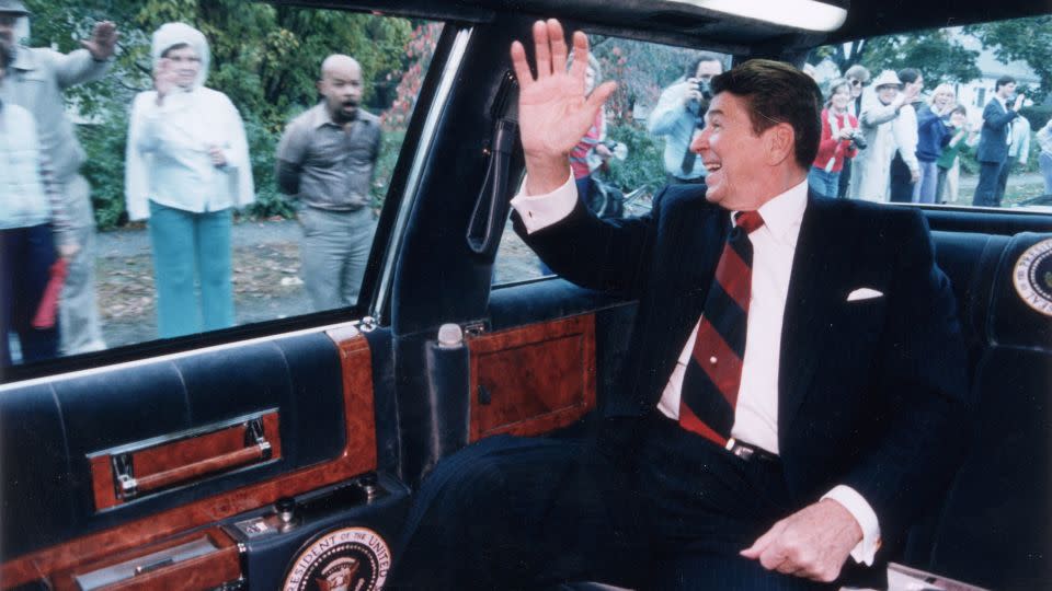 President Ronald Reagan waves from the back of his limousine to a line of people on the street as he heads toward a campaign stop in Fairfield, Connecticut, on October 26, 1984. - Ronald Reagan Library/Archive Photos/Getty Images