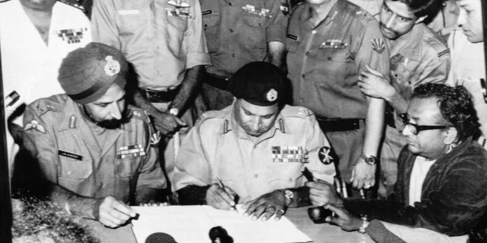 Lieutenant General A A K Niazi, Martial Law Administrator of East Pakistan, (center) signs the Surrender Document as Lieutenant General Jagjit Singh Aurora, Joint Commander of Indian and Bangladeshi Forces, (left) looks on December16, 1971 in Bangladesh. (AP Photo)