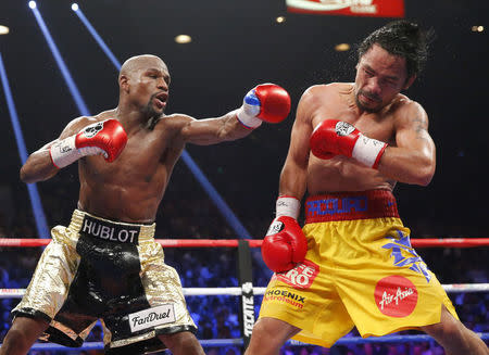 Floyd Mayweather, Jr. of the U.S. lands a left to the face of Manny Pacquiao of the Philippines (R) in the 11th round during their welterweight WBO, WBC and WBA (Super) title fight in Las Vegas, Nevada, May 2, 2015. REUTERS/Steve Marcus