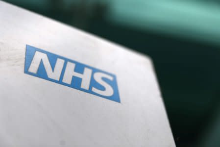 FILE PHOTO: An NHS logo is displayed outside a hospital in London, Britain May 14, 2017. REUTERS/Neil Hall