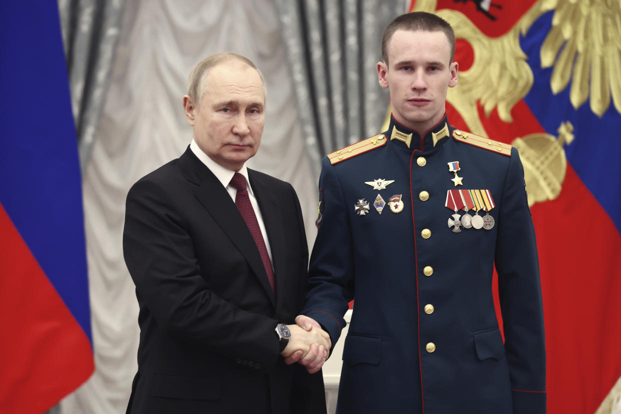 Russian President Vladimir Putin, left, awards Senior Lieutenant Stepan Belov with the Gold Star medal of the Hero of Russia during an awarding ceremony at the Kremlin's St. Catherine Hall in Moscow, Russia, Tuesday, Dec. 20, 2022. (Valeriy Sharifulin, Sputnik, Kremlin Pool Photo via AP)