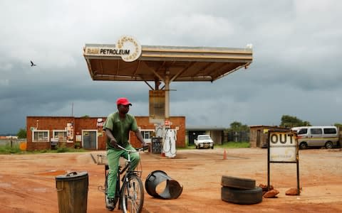 A man cycles past a petrol station closed after protests in Harare on Monday - Credit: &nbsp;PHILIMON BULAWAYO/&nbsp;REUTERS