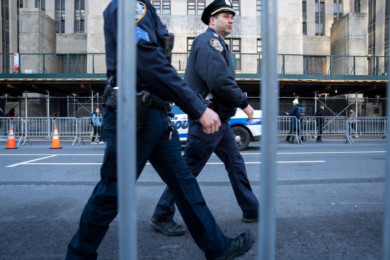 Police walk by the Manhattan Criminal Courthouse.