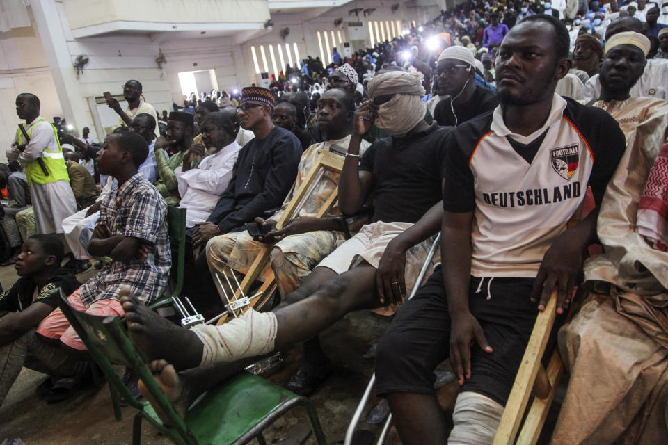 People who were wounded in July during opposition protests sit with others to attend a prayer service led by Mahmoud Dicko, an imam who helped lead the movement, for those who died or were injured during the protests, in Bamako, Mali Friday, Aug. 28, 2020. West African leaders on Friday urged Mali's junta to take no more than one year to hand over power to a civilian government, as regional heads of state held another virtual summit after initial negotiations with the military coup leaders failed. (AP Photo/Baba Ahmed)