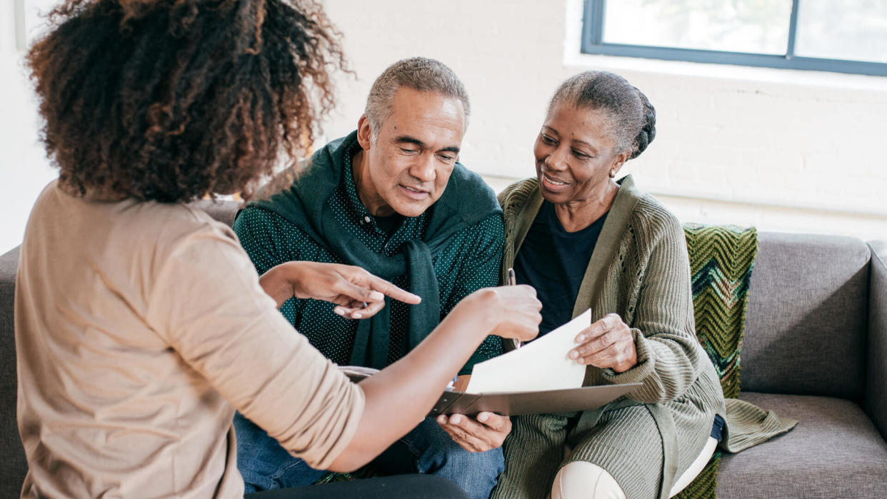 Financial advisor visiting seniors couple for consultation at home.