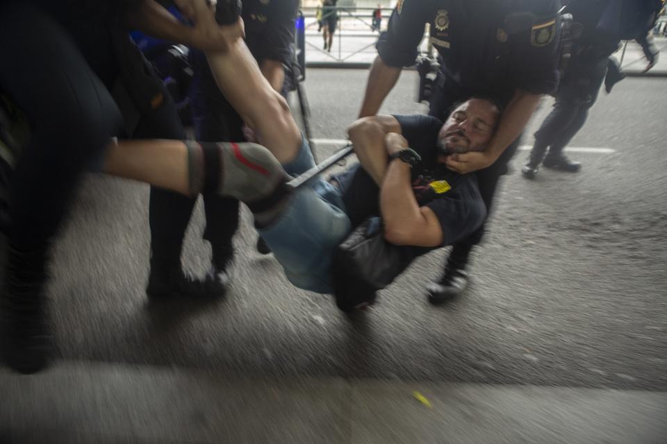 In this Monday, Oct. 14, 2019 photo, Spanish police carry a pro-independence protesters during a demonstration at El Prat airport, outskirts of Barcelona, Spain. Riot police engaged in a running battle with angry protesters outside Barcelona's airport Monday after Spain's Supreme Court convicted 12 separatist leaders of illegally promoting the wealthy Catalonia region's independence and sentenced nine of them to prison. (AP Photo/Joan Mateu)