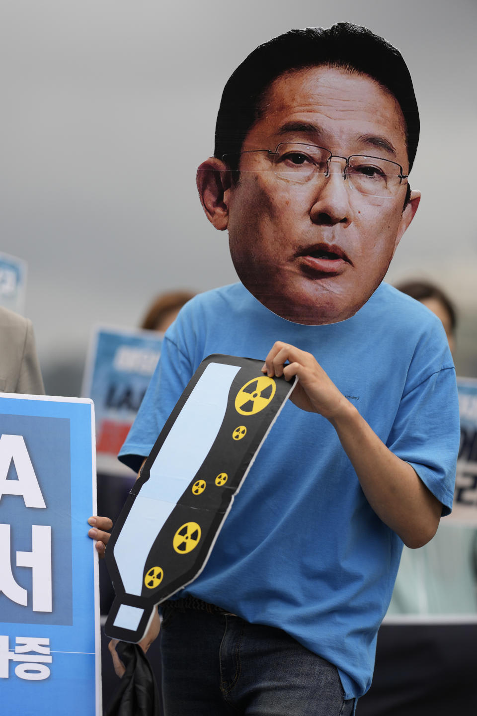 A member of civic groups wearing mask of Japanese Prime Minister Fumio Kishida, attends during a rally to oppose Japanese government's decision to release treated radioactive water into the sea from the Fukushima nuclear power plant, in Seoul, South Korea, Wednesday, July 5, 2023. (AP Photo/Lee Jin-man)