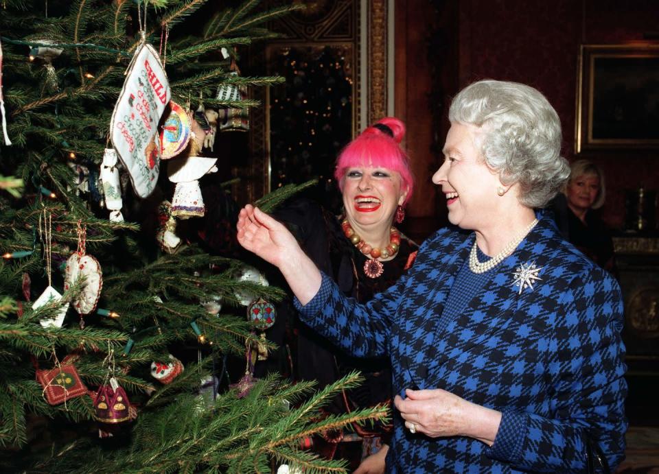 <p>Queen Elizabeth smiles as she views the ornaments on the tree in Buckingham Palace. Alongside her is fashion designer Zandra Rhodes, who was there for an event for celebrity and amateur embroiderers who made 500 ornaments for the Queen's tree. </p>