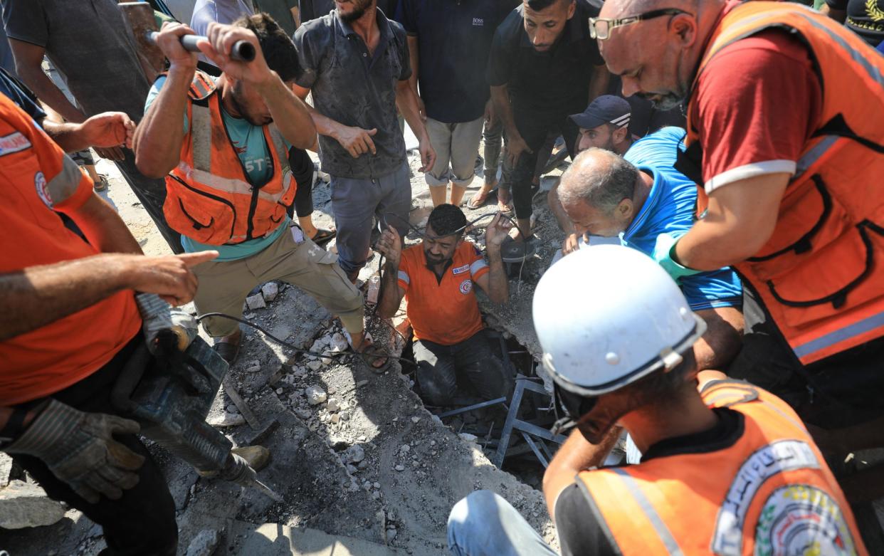 Palestinian residents of the area, together with civil defense teams, carry out search and rescue operations after the Israeli army attacked the Safad School