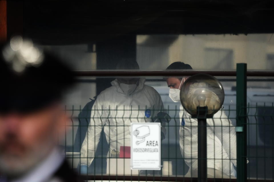 Forensic police officers inspect a bar where three people died after a man entered and shot in Rome, Sunday, Dec. 11, 2022. (AP Photo/Gregorio Borgia)