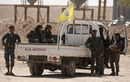 Fighters from Deir al-Zor military council which fights under the Syrian Democratic Forces (SDF) sit on a back of a truck in the village of Abu Fas, Hasaka province, Syria September 9, 2017. REUTERS/Rodi Said