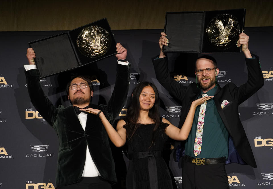 Los directores Daniel Kwan, izquierda, y Daniel Scheinert, derecha, posan en la sala de prensa acompañados por la presentadora Stephanie Hsu tras ganar el premio al mérito de dirección de largometraje por "Everything Everywhere All at Once" en la 75a entrega anual de los Premios del Sindicato de Directores de Estados Unidos el 18 de febrero de 2023 en el Hotel Beverly Hilton en Beverly Hills, California. (Foto AP/Chris Pizzello)