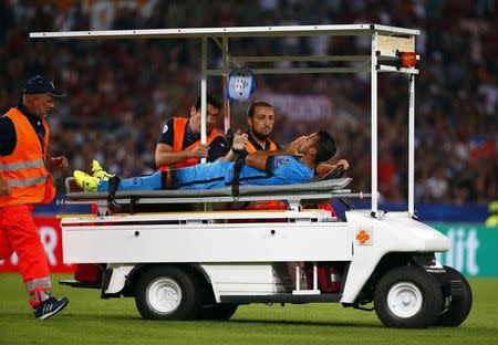 Barcelona's Rafinha is carried off the pitch after getting injured during the match against AS Roma in their Champions League Group E stage match at the Olympic stadium in Rome, Italy , September 16, 2015. REUTERS/Tony Gentile