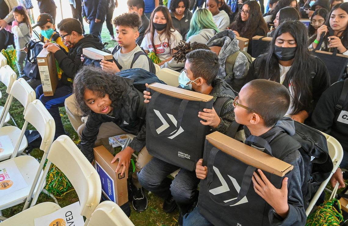 Area school kids hold onto their free laptops donated by the Comcast company during an event at Saint Rest Baptist Church in west Fresno on Thursday, Oct. 27, 2022.