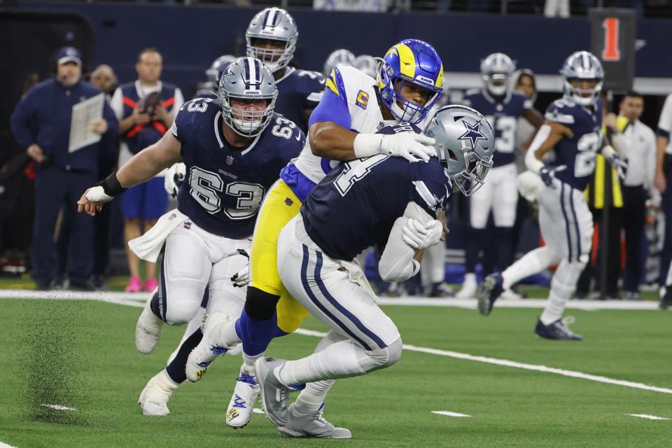 Los Angeles Rams defensive tackle Aaron Donald, second from right, sacks Dallas Cowboys quarterback Dak Prescott (4) during the first half of an NFL football game Sunday, Oct. 29, 2023, in Arlington, Texas. (AP Photo/Michael Ainsworth)