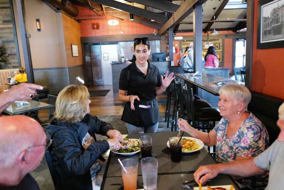 Server at One North Kitchen and Bar, Karina Long, checks in with her customers Thursday Aug. 10, 2023. 