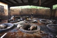 Men work in a leather tannery in Niamey, September 14, 2013. REUTERS/Joe Penney