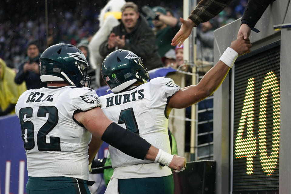 Philadelphia Eagles quarterback Jalen Hurts (1) celebrates with center Jason Kelce (62) as they are congratulated by fans after Hurts scored a touchdown against the New York Giants during the third quarter of an NFL football game, Sunday, Dec. 11, 2022, in East Rutherford, N.J. (AP Photo/Bryan Woolston)