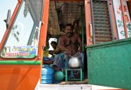 A driver cooks food inside his parked supply truck at a yard during a 21-day nationwide lockdown to limit the spreading of coronavirus disease (COVID-19), on the outskirts of Kolkata