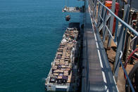 Humanitarian aid is lifted by a crane operated by soldiers assigned to the 7th Transportation Brigade (Expeditionary) from a Navy causeway at the Port of Ashdod, Israel, May 14, 2024. These soldiers are supporting the construction of the Joint Logistics Over-the-Shore system off the shore of Gaza. (Staff Sgt. Malcolm Cohens-Ashley/U.S. Army via AP)