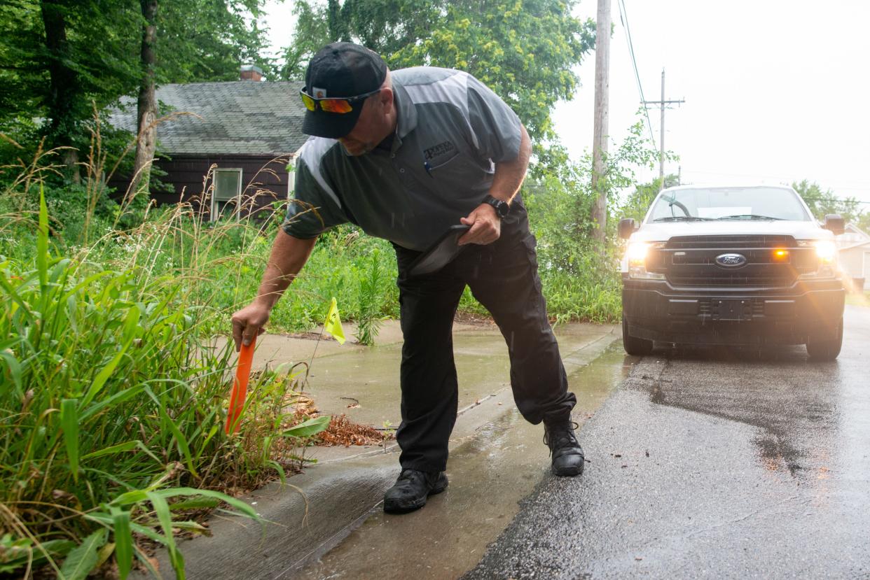 Topeka public works field supervisor John Schardine took a measurement Thursday morning near N.E. Grant and Monroe to determine whether grass there was higher than the maximum 12 inches allowed by Topeka's city government.