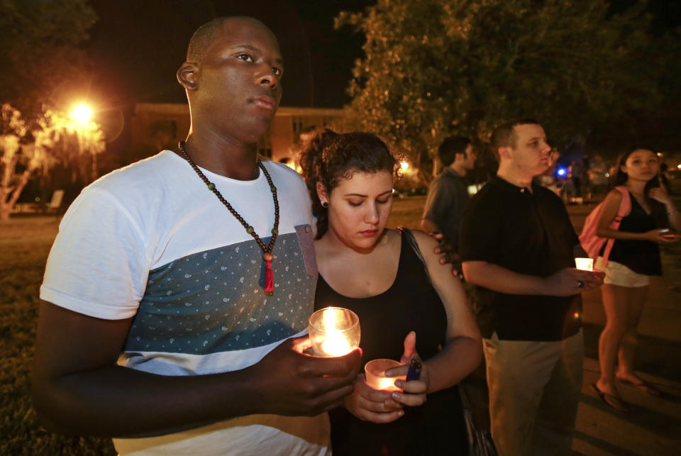 FILE - Julian Lang, left, and Andrea Henriquez join students and supporters in a candle light vigil at the University of Central Florida, Wednesday, Sept. 3, 2014, in Orlando, Fla., to honor Steven Sotloff, the second American journalist to be beheaded by the Islamic State group in two weeks. Sotloff attended University of Central Florida between 2002 and 2004. The family of slain American journalist Steven Sotloff filed a federal lawsuit Friday, May 13, 2022, accusing prominent Qatari institutions of wiring $800,000 to an Islamic State “judge” who ordered the murder of Sotloff and another American journalist, James Foley. (AP Photo/John Raoux, File)