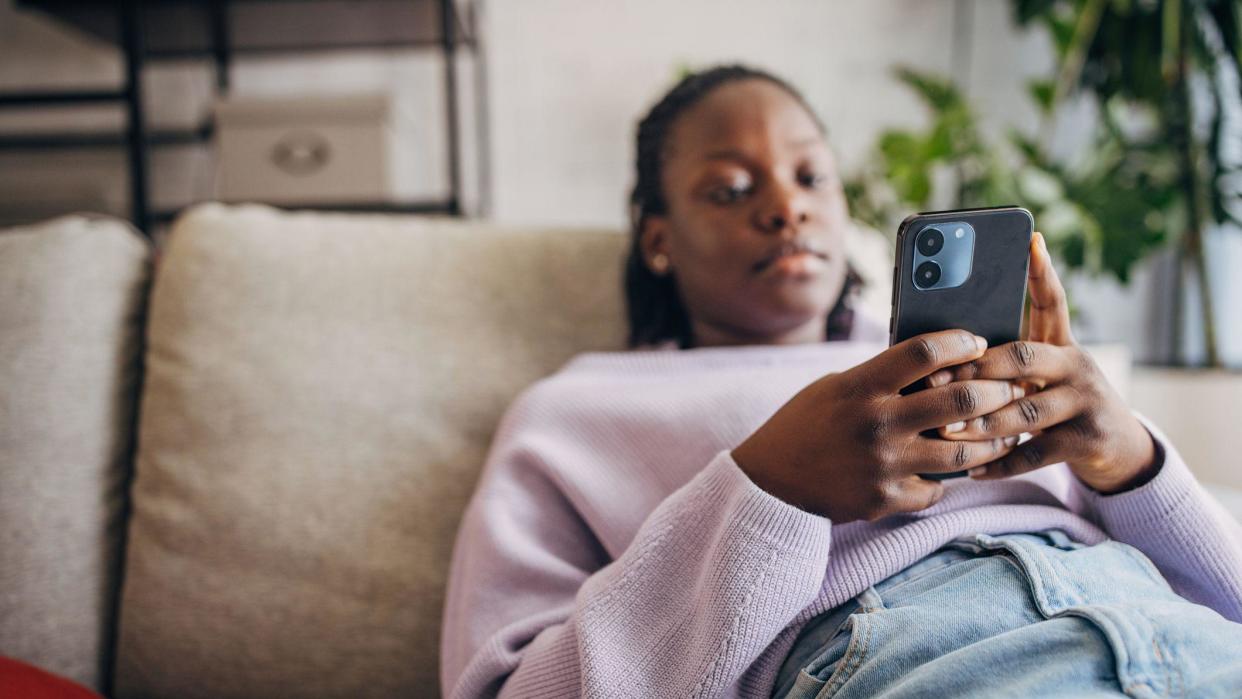 Woman looking at her phone on the sofa