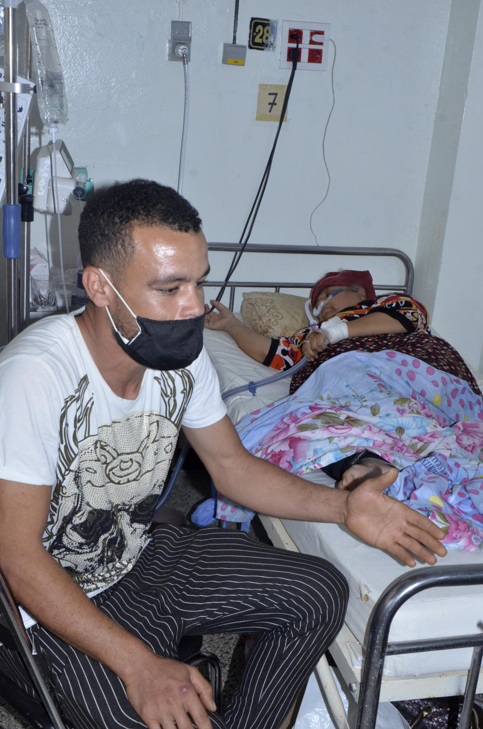 A man sits by a relative infected with the COVID-19 virus in the Iben El Jazzar hospital in Kairouan, Tunisia, Monday, June 28, 2021.Confirmed virus infections in Tunisia have grown sharply over the last month to the highest daily levels since the pandemic began, while the vaccination rate remains low, according to data from John's Hopkins University. The data indicate that Tunisia has reported Africa's highest per-capita death toll from the pandemic, and is currently recording one of the highest per-capita infection rates in Africa. (Photo/Aimen Othmani)