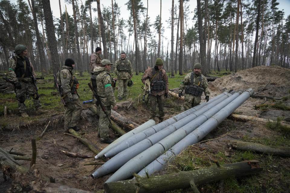 Ukrainian soldiers examine Russian multiple missiles abandoned by Russian troops, in the village of Berezivka, Ukraine, Thursday, April 21, 2022. (AP Photo/Efrem Lukatsky)