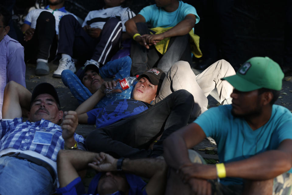 Scores of Central American migrants, representing the thousands participating in a caravan trying to reach the U.S. border, rest in front of the office of the United Nation's human rights body, after undertaking an hours-long march to demand buses, in Mexico City, Thursday, Nov. 8, 2018. Members of the caravan which has stopped in Mexico City demanded buses Thursday to take them to the U.S. border, saying it is too cold and dangerous to continue walking and hitchhiking.(AP Photo/Rebecca Blackwell)