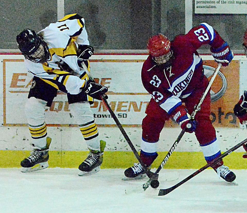 Jake Bramer of the Watertown Lakers (11) and Jack Merritt of the Brookings Rangers (23) battle for the puck during their South Dakota Amateur Hockey Association varsity boys' game Thursday night in the Maas Ice Arena. Brookings won 8-0.