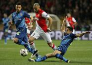 AS Monaco's Layvin Kurzawa (C) makes his way through Arsenal's Francis Coquelin (L) and Alexis Sanchez (R) during their Champions League round of 16 second leg soccer match at the Louis II Stadium in Monaco, March 17, 2015. REUTERS/Eric Gaillard (MONACO - Tags: SPORT SOCCER)