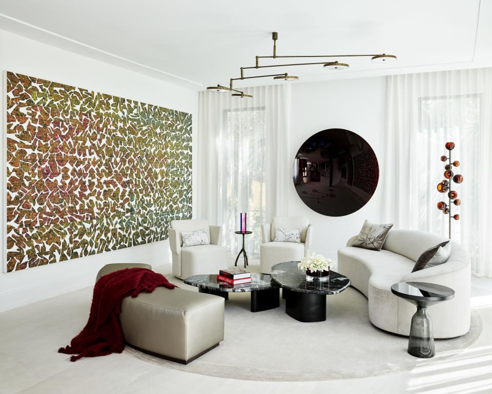 More of radio host Tom Joyner’s enviable art collection is on display in his Golden Beach, Florida, living room, designed by Deborah Wecselman. The black Anish Kapoor mirror is so heavy that the wall behind it actually had to be reinforced before it could be hung. The large piece on the left is by Allora & Calzadilla and is made out of broken solar panel fragments. Wecselman opted for white and beige furniture to make the art pop even more: The sofa is custom designed by her; and the coffee tables, chairs, pendant light, and floor lamp are all sourced from Holly Hunt.