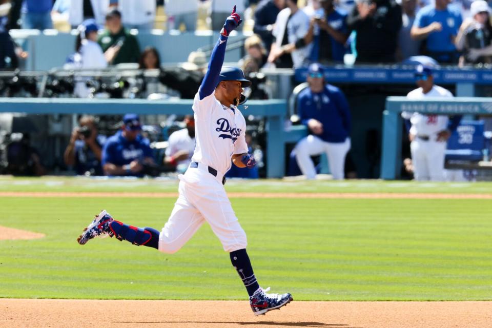 Los Angeles Dodgers' Mookie Betts celebrates while rounding the bases after hitting a home run.