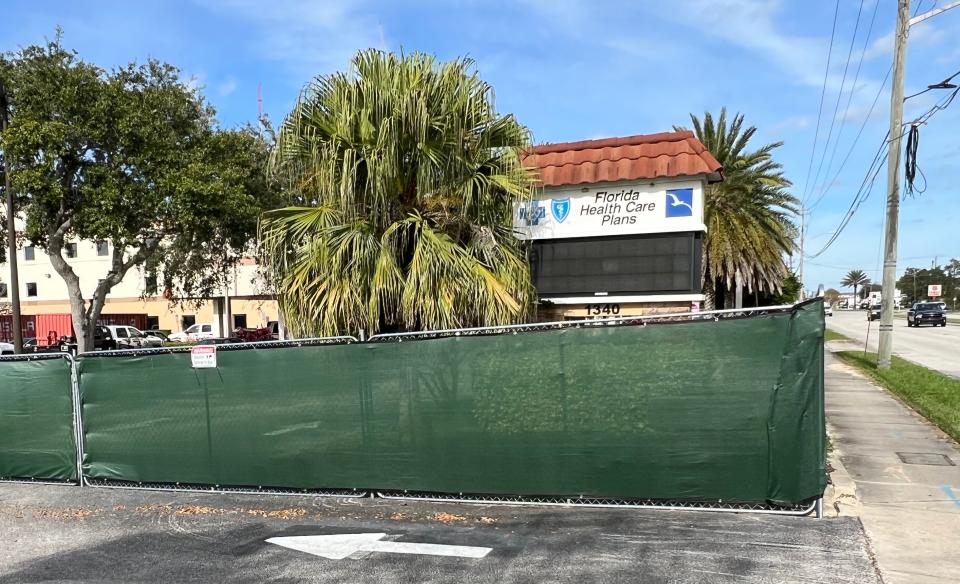 A construction fence can be seen surrounding the former Florida Health Care Plans headquarters at 1340 Ridgewood Ave. in Holly Hill on Nov. 30, 2023. The property was recently sold. The interior of existing three-story building on the south side will be gutted and renovated to become part of a new Devon Self Storage Center. The single-story building on the north side will be demolished to make way for a new three-story building that will also be part of the storage center.
