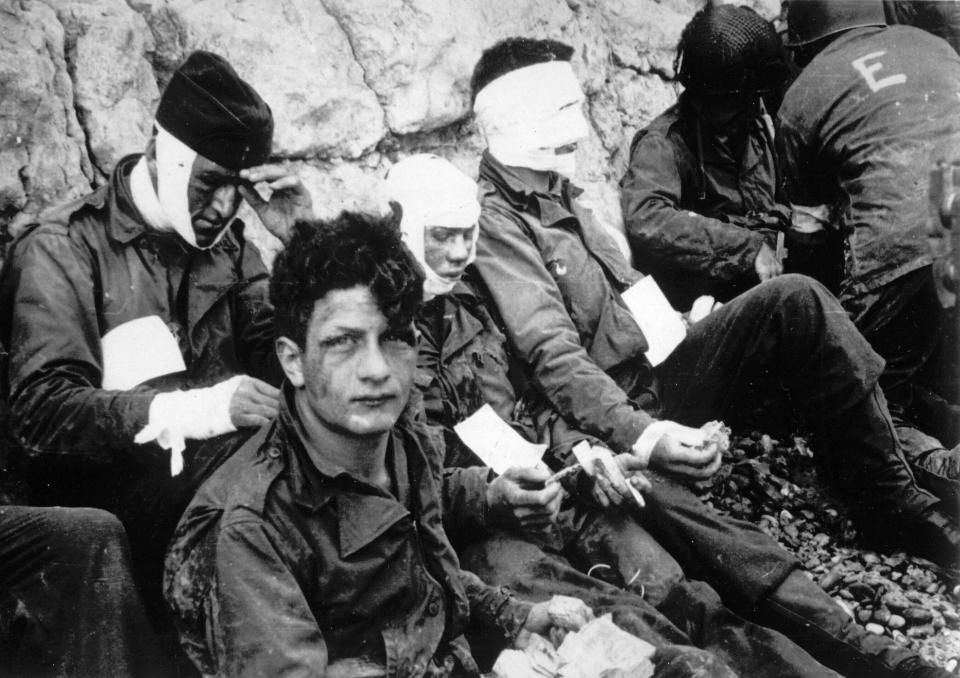 Men of the American assault troops of the 16th Infantry Regiment, injured while storming a coastal area code-named Omaha Beach during the Allied invasion of the Normandy, wait by the chalk cliffs at Collville-sur-Mer for evacuation to a field hospital for further treatment, June 6, 1944. On D-Day, Charles Shay was a 19-year-old Native American army medic who was ready to give his life — and actually saved many. Now 99, he's spreading a message of peace with tireless dedication as he's about to take part in the 80th celebrations of the landings in Normandy that led to the liberation of France and Europe from Nazi Germany occupation. (AP Photo, File)