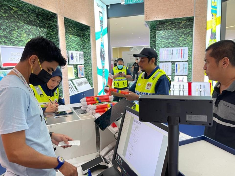 Home Ministry officers with seized Swatch watches at One Utama mall. — Picture courtesy of Swatch